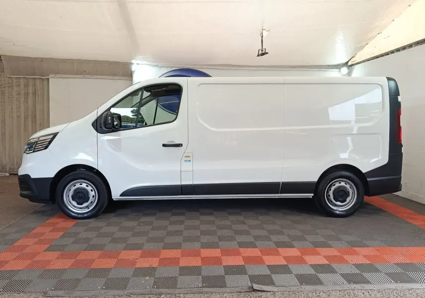 Vue de profil côté gauche d’un Renault Trafic Fourgon blanc 2023 avec jantes acier et portes latérales pleines.