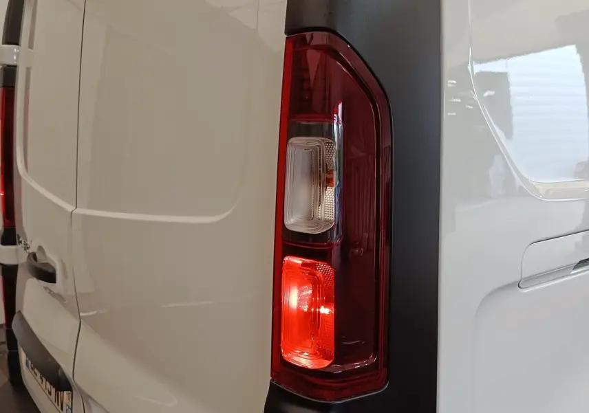 Gros plan sur le feu arrière droit rouge et blanc du Renault Trafic Fourgon blanc, vue arrière côté droit.
