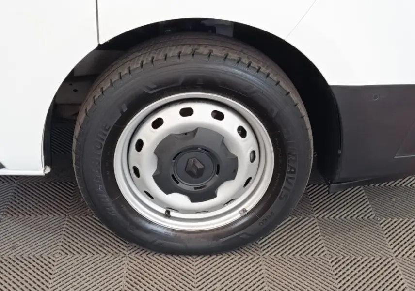 Gros plan sur la roue arrière droite blanche du Renault Trafic Fourgon 2023 avec jante acier et logo Renault central.