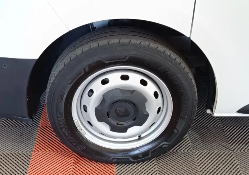 Gros plan sur la roue avant droite en jante acier du Renault Trafic Fourgon blanc, avec pneu Bridgestone.