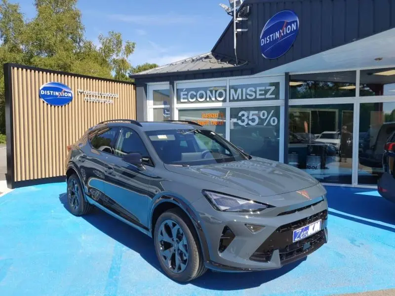 SUV CUPRA Formentor gris en 3/4 avant droit, avec jantes noires et détails sportifs visibles au showroom.