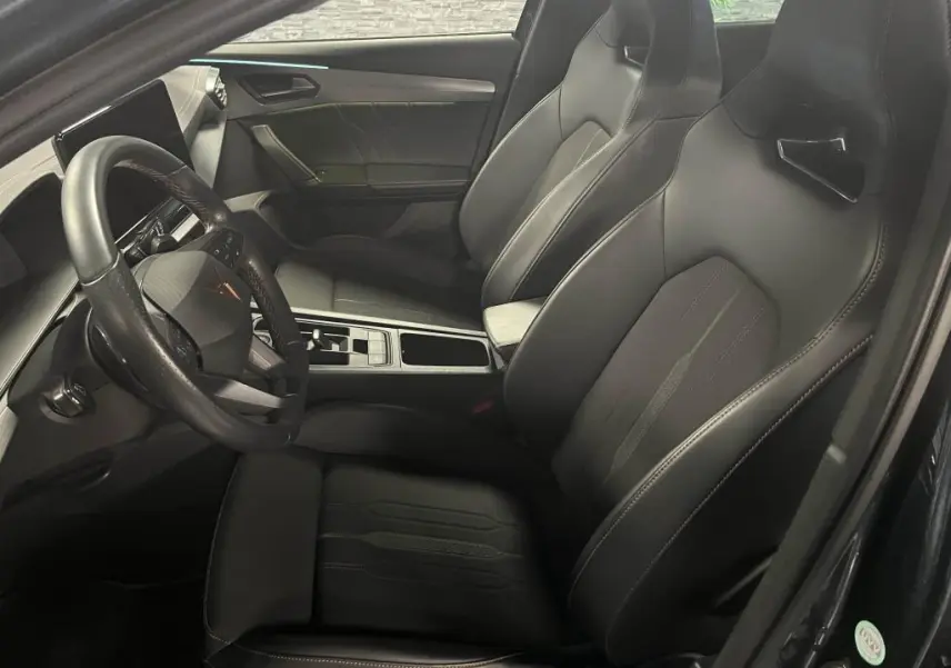 Intérieur avant du CUPRA Formentor 1.4 e-Hybrid 2023, sièges baquets noirs et volant sport multifonction cuir.