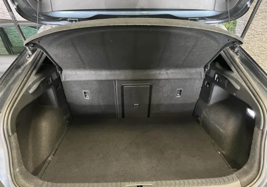 Coffre ouvert vu de l'arrière du CUPRA Formentor gris, montrant un espace de chargement propre et bien fini.