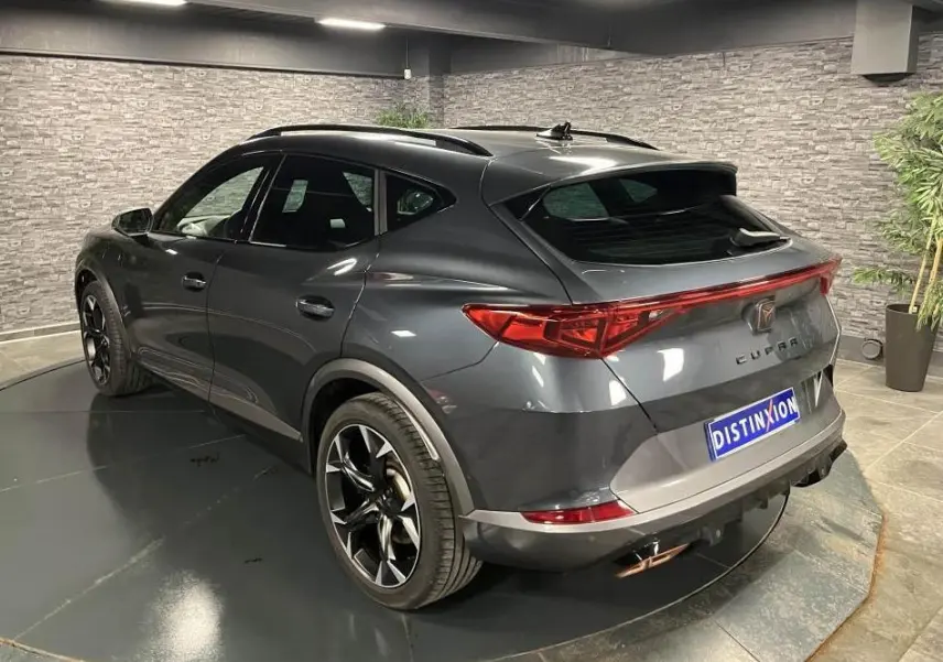 Vue 3/4 arrière droite du CUPRA Formentor gris magnétique 2023 avec feux arrière LED en bandeau et double sortie d'échappement copper.