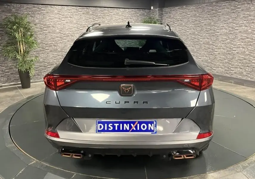 Vue arrière d'un CUPRA Formentor gris magnétique avec bandeau LED arrière Infinite Light et double sortie d'échappement copper.