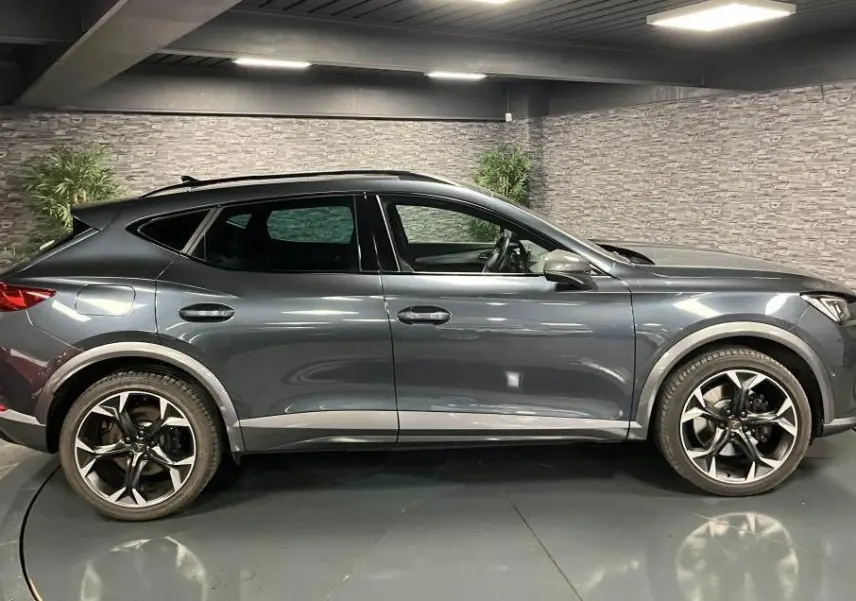Vue de profil côté gauche du CUPRA Formentor gris magnétique 2023 avec jantes alliage 19 pouces et toit noir.