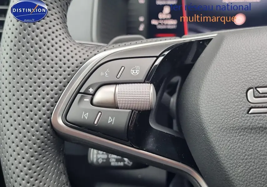 Gros plan sur les commandes au volant cuir perforé du Skoda Karoq noir, version sportline 2025.