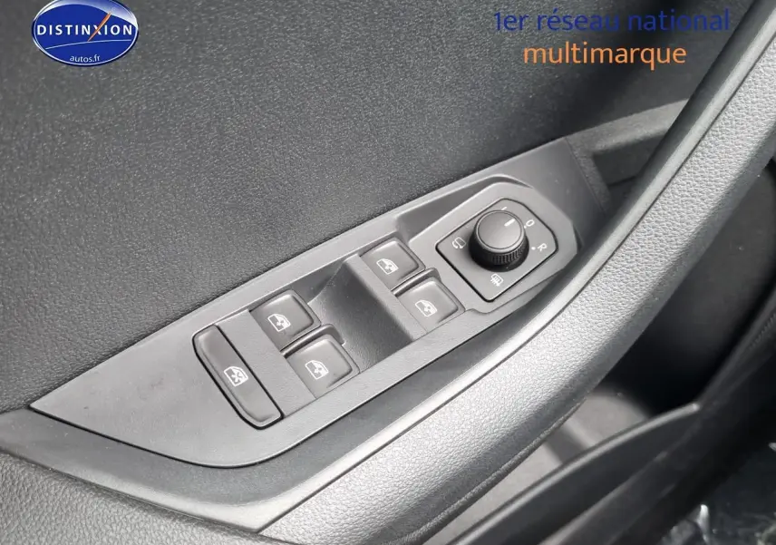 Gros plan sur les commandes des vitres et rétroviseurs côté conducteur d’un Skoda Karoq noir 2025.