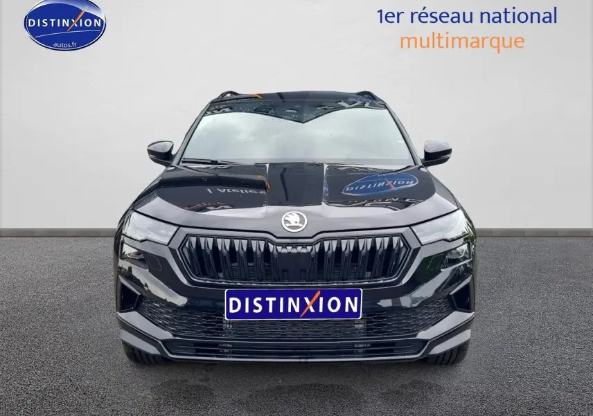 Vue de face d'un Skoda Karoq noir 2025 avec calandre noire et logo centré, sur fond neutre.