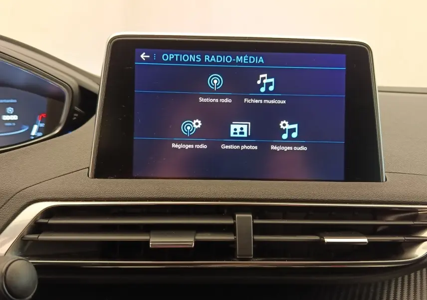 Écran tactile central affichant les options radio-média dans l’habitacle du Peugeot 5008 gris foncé, vue de face.
