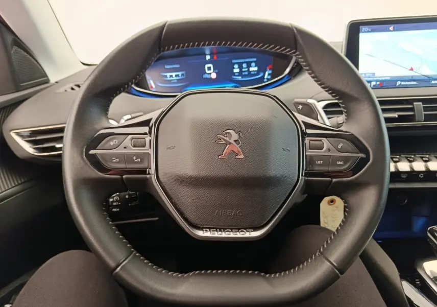 Vue intérieure centrée sur le volant cuir noir du Peugeot 5008 2020 avec tableau de bord digital et écran tactile.