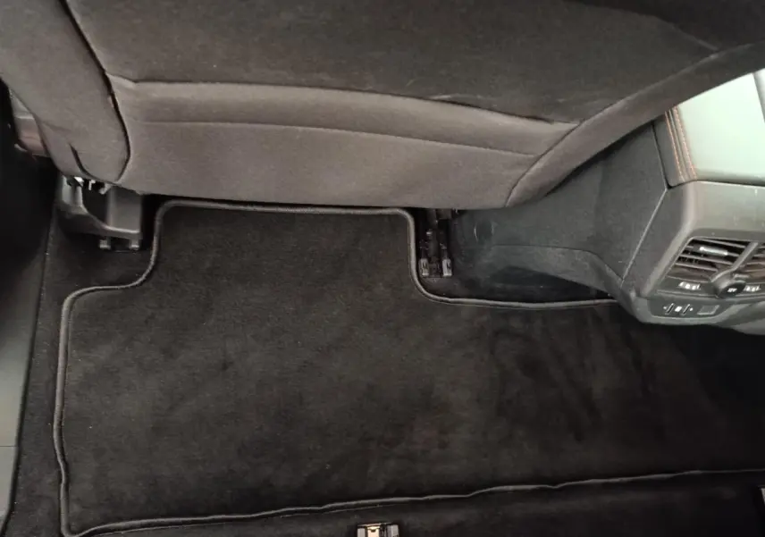 Vue intérieure du plancher arrière côté droit du Peugeot 5008 gris foncé avec tapis de sol noir et aérateurs arrière.