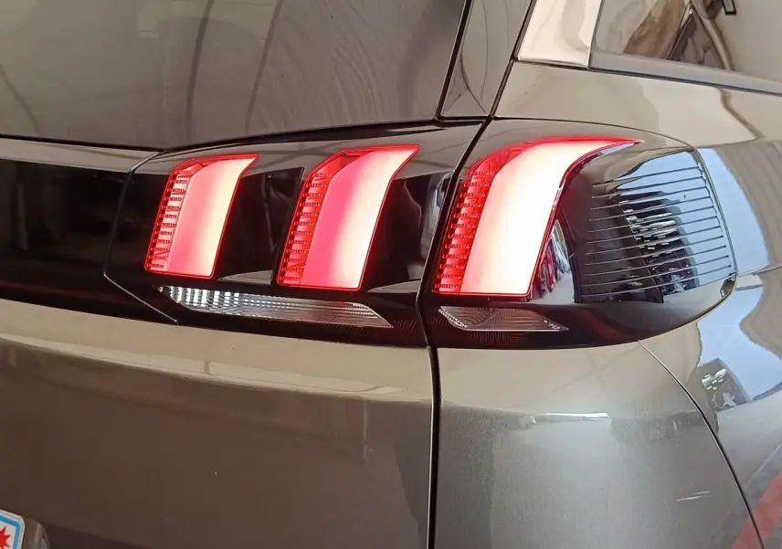 Gros plan sur le feu arrière droit rouge et blanc du Peugeot 5008 gris foncé, version 2020.