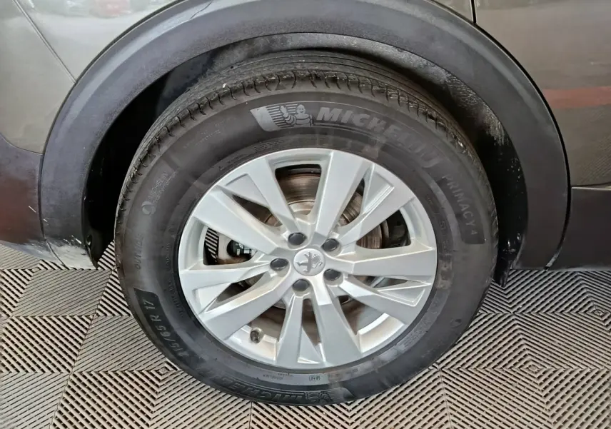 Gros plan sur la roue avant gauche grise d’un Peugeot 5008 2020 avec jante alliage et pneu Michelin.