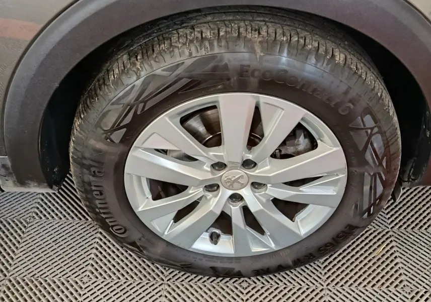 Gros plan sur la roue avant gauche du Peugeot 5008 gris foncé, avec jante alliage et pneu Continental EcoContact 6.
