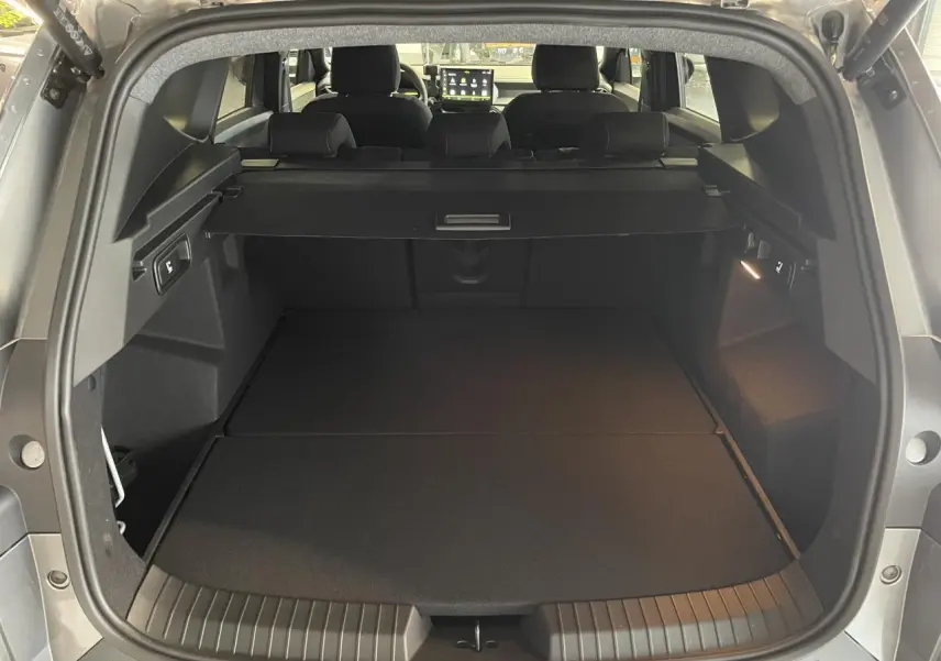 Coffre ouvert vu de l'arrière du Dacia Bigster gris schiste, avec banquette arrière et tablette cache-bagages visibles.