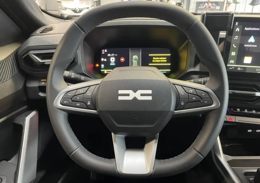 Vue intérieure centrée sur le volant noir du Dacia Bigster 2026 avec tableau de bord numérique et écran tactile latéral.