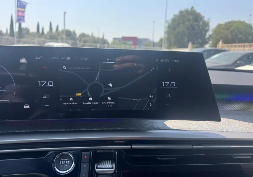 Vue rapprochée du tableau de bord numérique du Peugeot 3008 Hybrid 145 e-DCS6 GT noir, affichant la navigation et la climatisation.