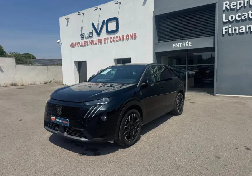 Vue 3/4 avant d'un Peugeot 3008 Hybrid 145 e-DCS6 GT noir, avec jantes alliage 19 pouces, devant un concessionnaire.