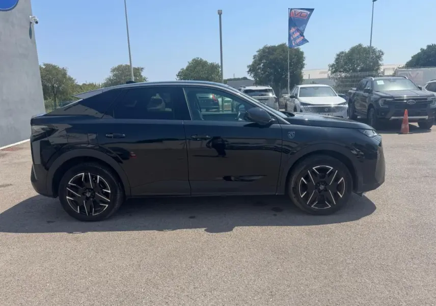 Profil droit d’un Peugeot 3008 Hybrid 145 e-DCS6 GT noir avec jantes alliage 19 pouces, garé en extérieur par temps clair.