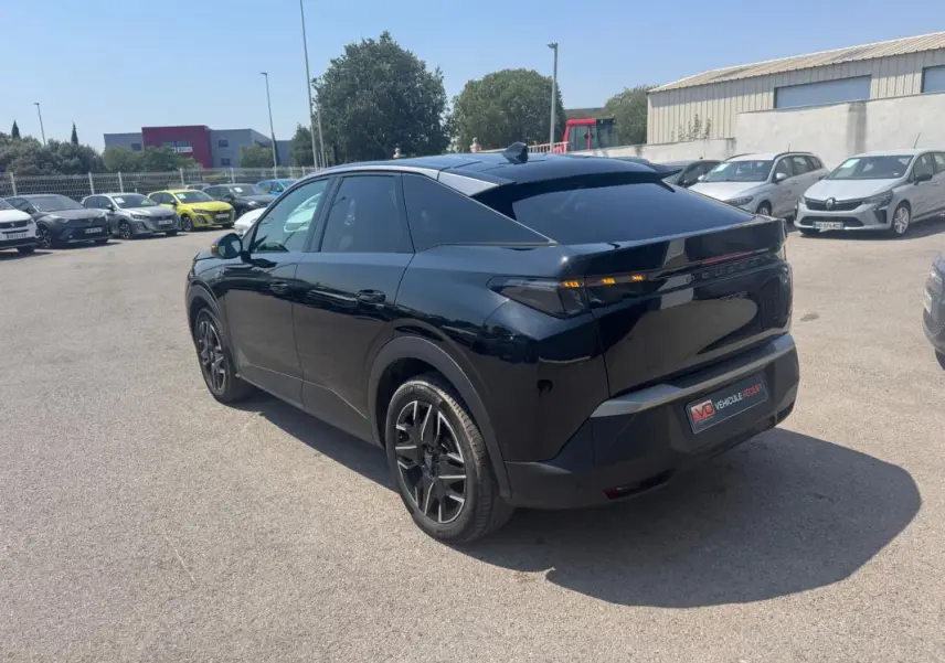 Vue 3/4 arrière droite d'un Peugeot 3008 Hybrid noir avec jantes alliage 19 pouces, stationné en extérieur.