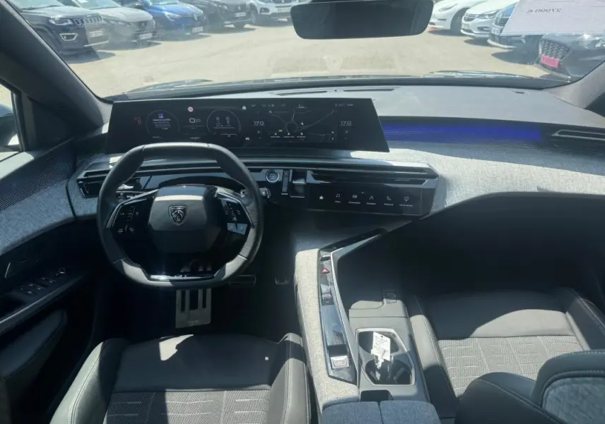 Vue intérieure du poste de conduite du Peugeot 3008 Hybrid 145 e-DCS6 GT 2025, avec cockpit numérique et volant compact.