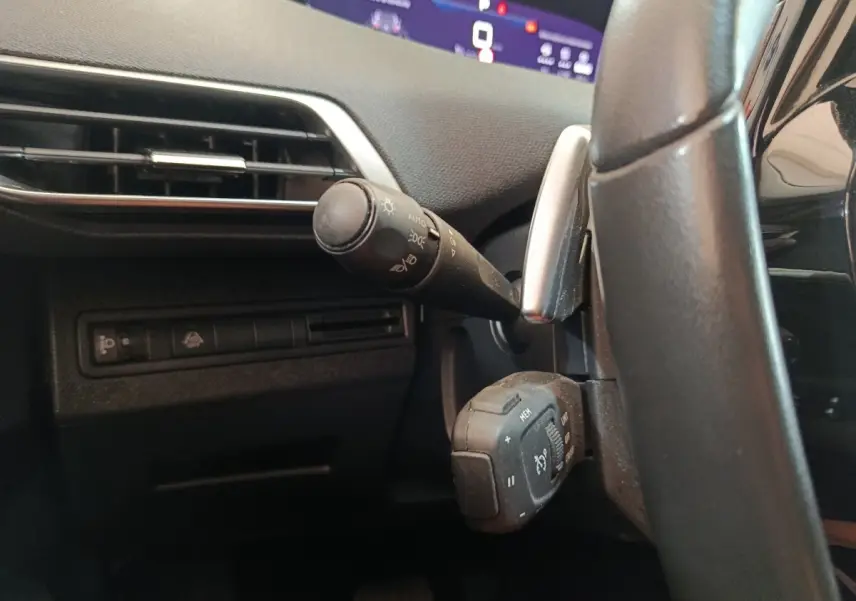Détail côté gauche du volant noir du Peugeot 3008 2022, avec commandes d’éclairage et affichage digital partiel.