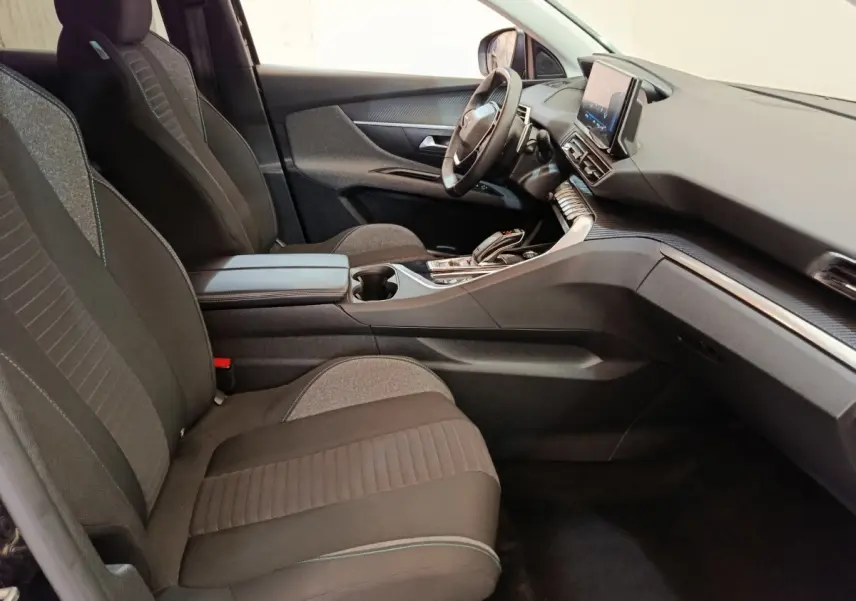 Intérieur du Peugeot 3008 2022, vue côté conducteur, sièges tissu noirs et tableau de bord avec écran tactile central.