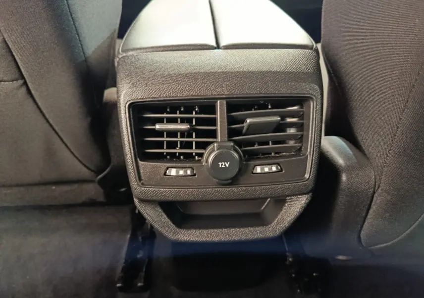 Vue rapprochée des commandes de ventilation arrière et prise 12V sur console centrale noire du Peugeot 3008 2022.