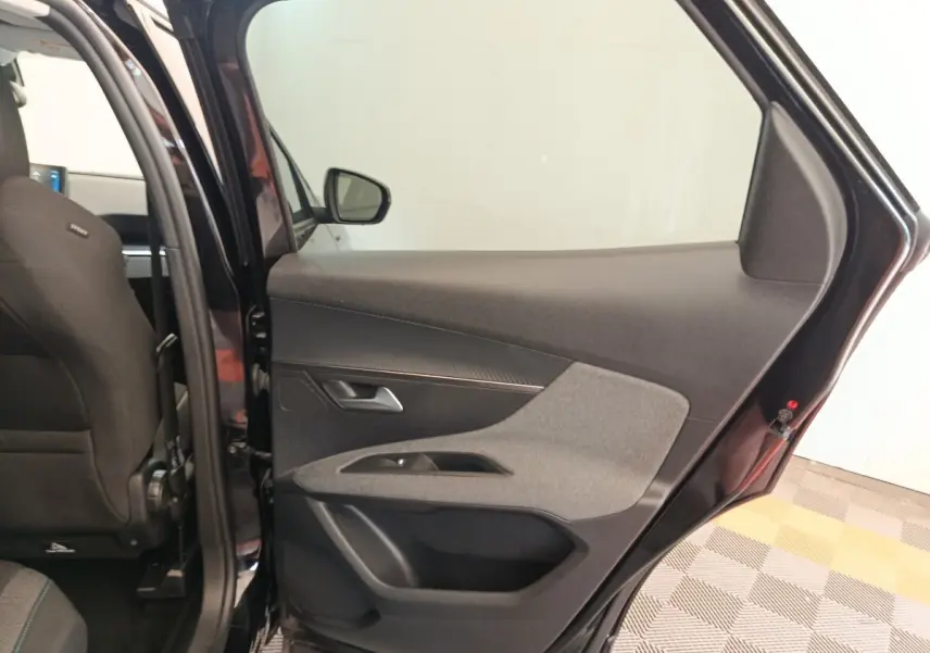 Vue intérieure côté droit de la porte arrière noire du Peugeot 3008 2022 avec garniture tissu et plastique.