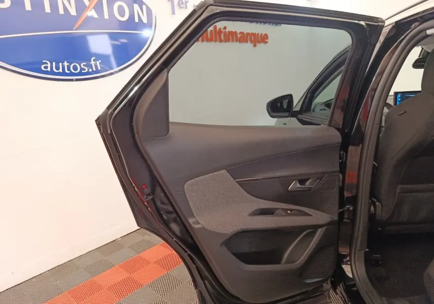Vue intérieure de la porte arrière gauche ouverte d’un Peugeot 3008 noir, montrant les garnitures et la poignée.