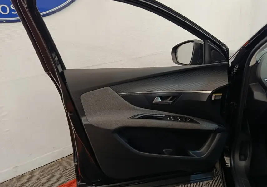 Vue intérieure de la porte avant gauche noire du Peugeot 3008 2022 avec commandes de vitres et insert décoratif gris.