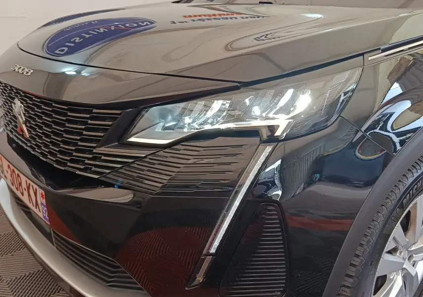 Vue 3/4 avant droit d’un Peugeot 3008 noir 2022 avec phares LED allumés et calandre distinctive.