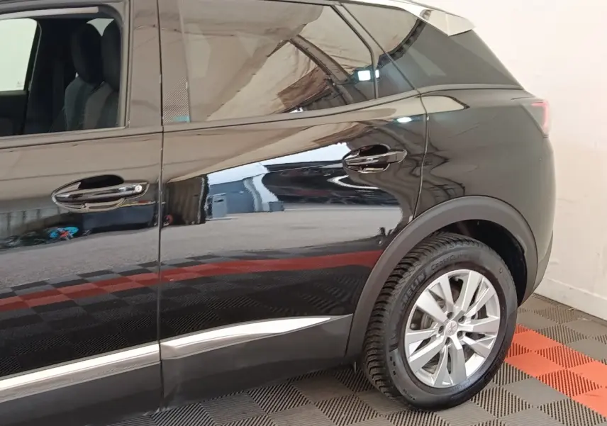 Vue latérale droite du Peugeot 3008 noir 2022, mettant en valeur la roue arrière et les lignes de caisse brillantes.