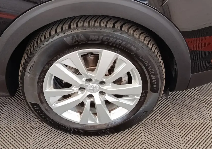Gros plan sur la roue avant droite d’un Peugeot 3008 noir, pneu Michelin CrossClimate 17 pouces.