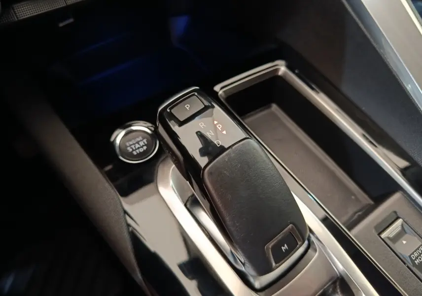 Gros plan sur la commande de boîte automatique et bouton start/stop du Peugeot 3008 noir, intérieur moderne et soigné.
