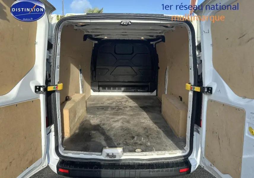 Vue arrière ouverte du fourgon blanc Ford Transit Custom 2021 montrant l'espace de chargement vide et les portes battantes.