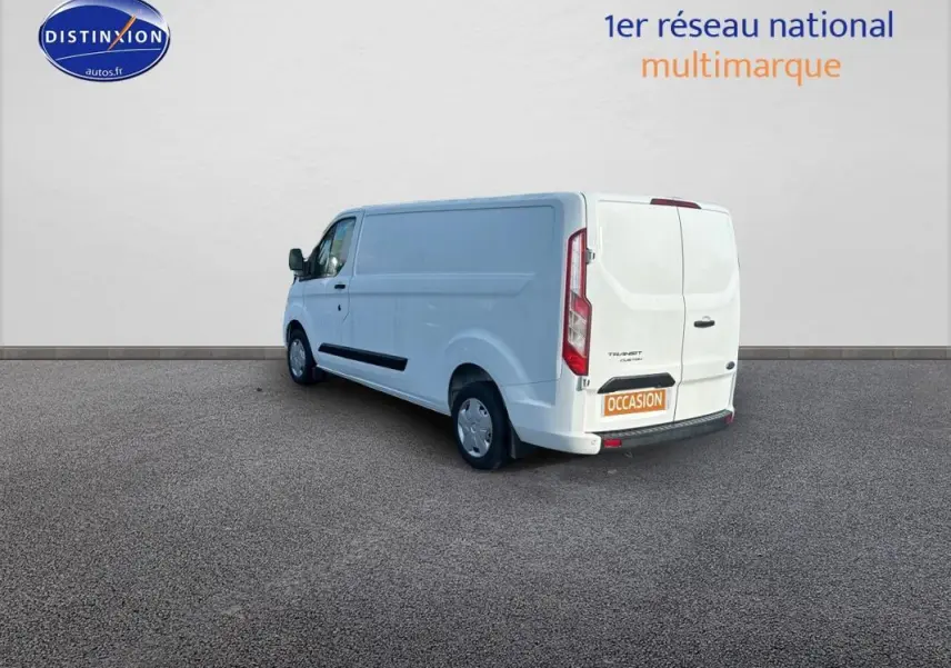 Ford Transit Custom blanc vu en 3/4 arrière droit, fourgon utilitaire avec porte latérale et vitres surteintées.