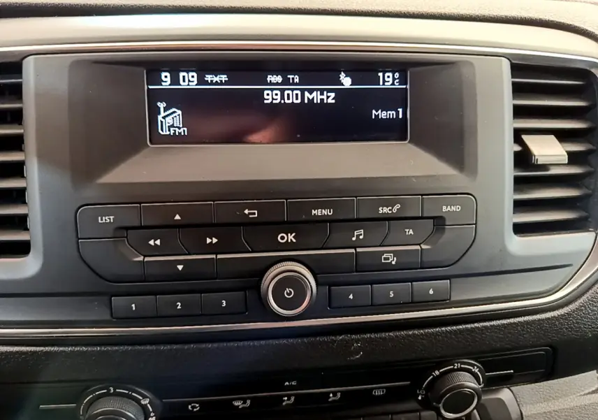 Vue rapprochée de la radio et commandes centrales du tableau de bord du Toyota Proace Verso gris clair de 2019.