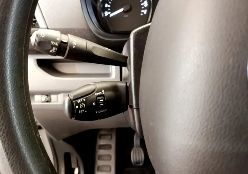 Gros plan sur les commandes de régulateur de vitesse et des phares derrière le volant du Toyota Proace Verso gris clair 2019.