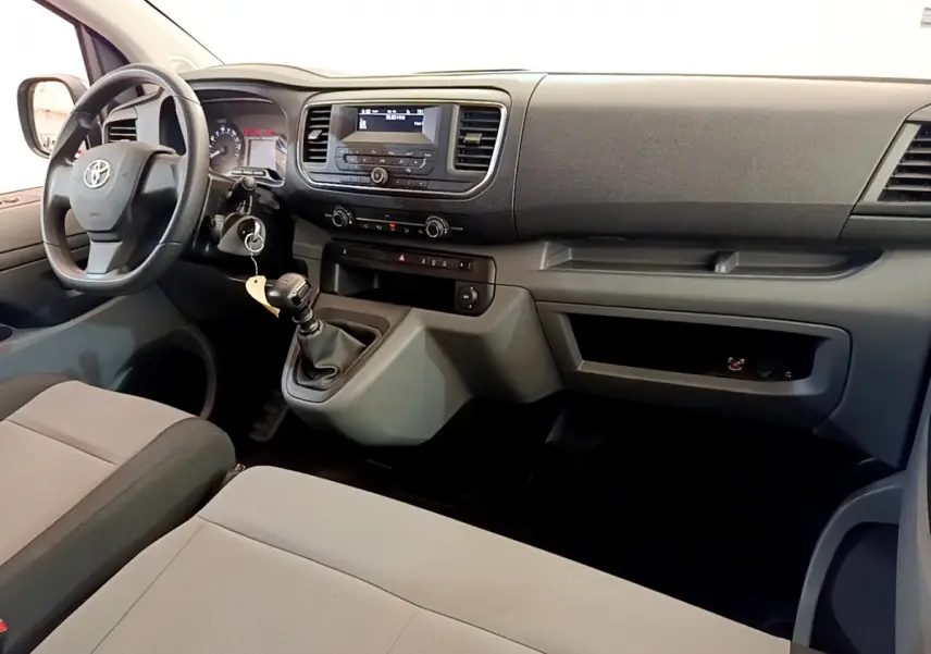 Intérieur avant du Toyota Proace Verso 2019, tableau de bord gris avec volant multifonction et levier de vitesses manuel.