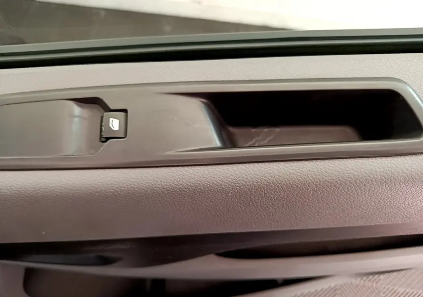 Gros plan sur la poignée intérieure de porte avant droite du Toyota Proace Verso gris clair, avec bouton de verrouillage.