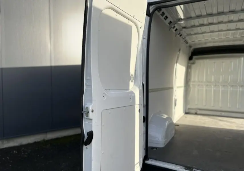 Vue intérieure côté droit du fourgon blanc Opel Movano 2.2 BlueHDi 140 L3H2 avec porte arrière ouverte et espace de chargement vide.
