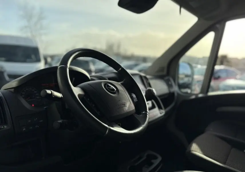 Intérieur de l’Opel Movano Fourgon 2023, vue côté conducteur sur le volant et tableau de bord noir.