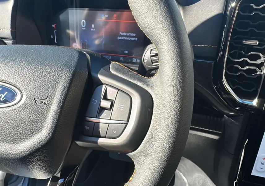 Gros plan sur le volant cuir multifonctions et le tableau de bord numérique du Ford Ranger 2025 gris iconic.