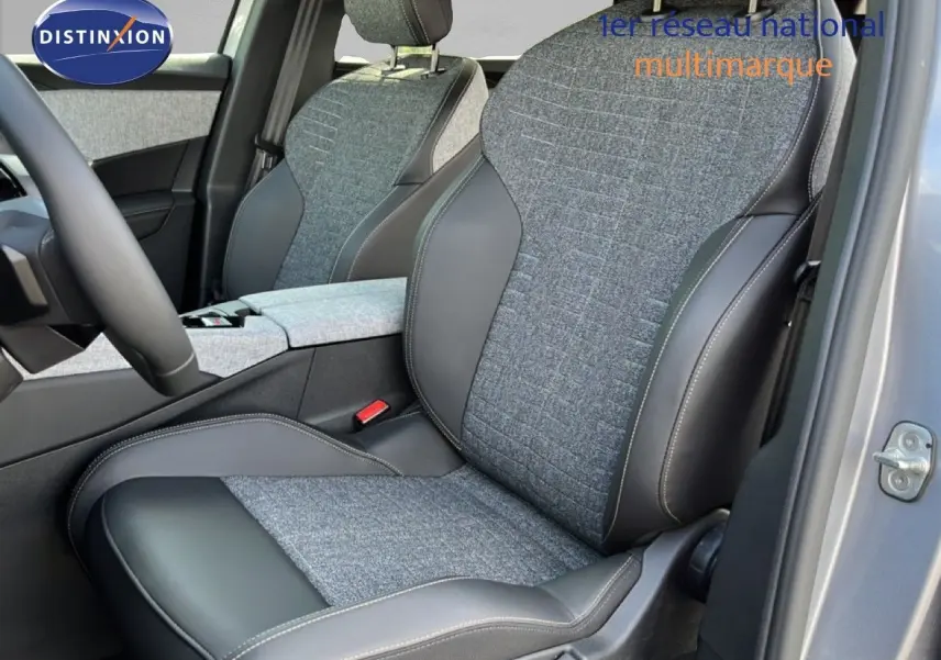 Vue intérieure sur les sièges avant gris tissu et cuir du Peugeot 5008 Hybrid 2025, avec portière ouverte côté droit.