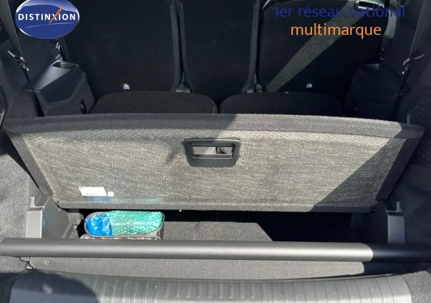 Coffre ouvert du Peugeot 5008 gris Artense, montrant le compartiment de rangement sous plancher et les sièges arrière rabattus.