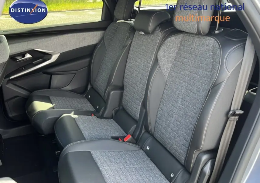 Vue latérale intérieure montrant les sièges arrière en tissu gris et cuir noir du Peugeot 5008 Hybrid 2025 gris Artense métal.