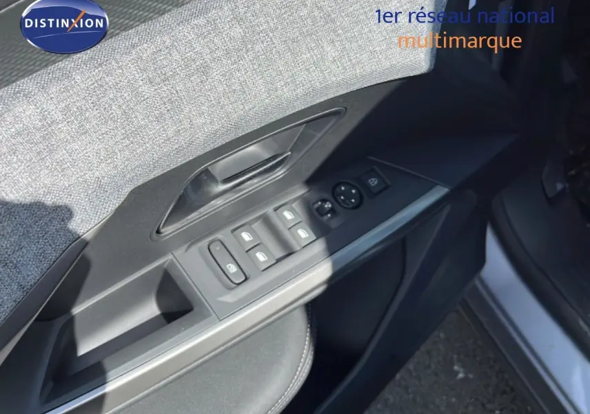 Gros plan sur la porte avant gauche du Peugeot 5008 gris Artense, montrant les commandes des vitres et rétroviseurs.