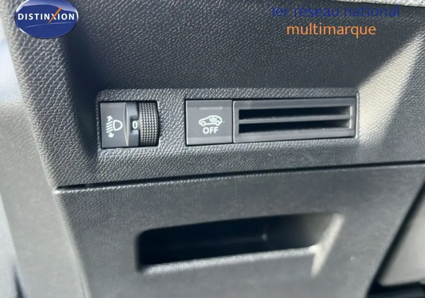 Détail intérieur montrant les commandes de réglage des phares et l'aération côté conducteur du Peugeot 5008 gris Artense 2025.